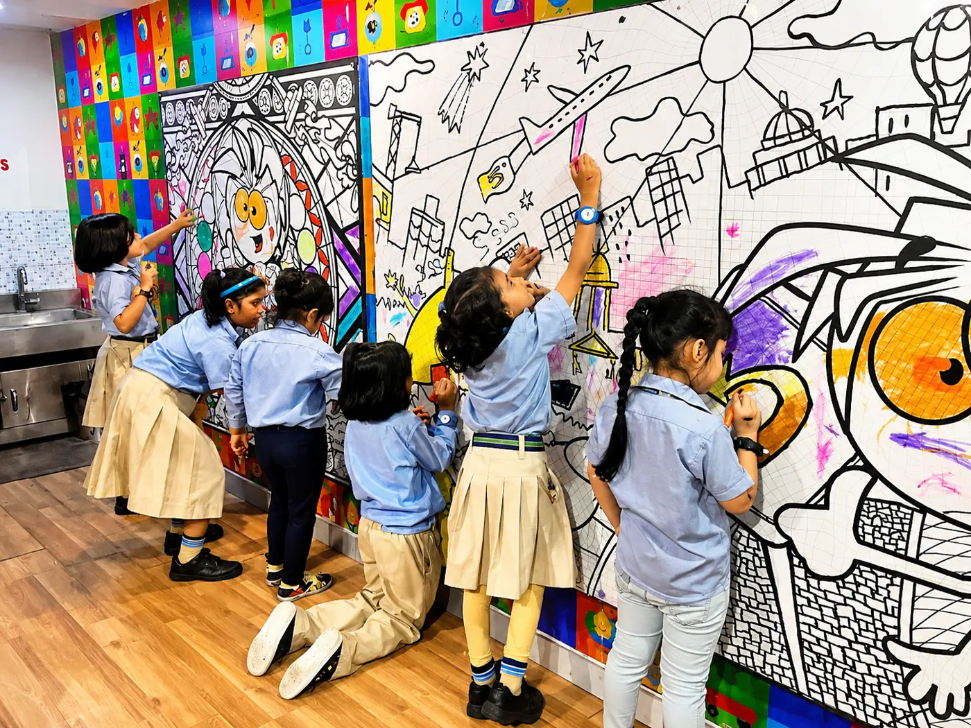 Students creating a colourful wall mural