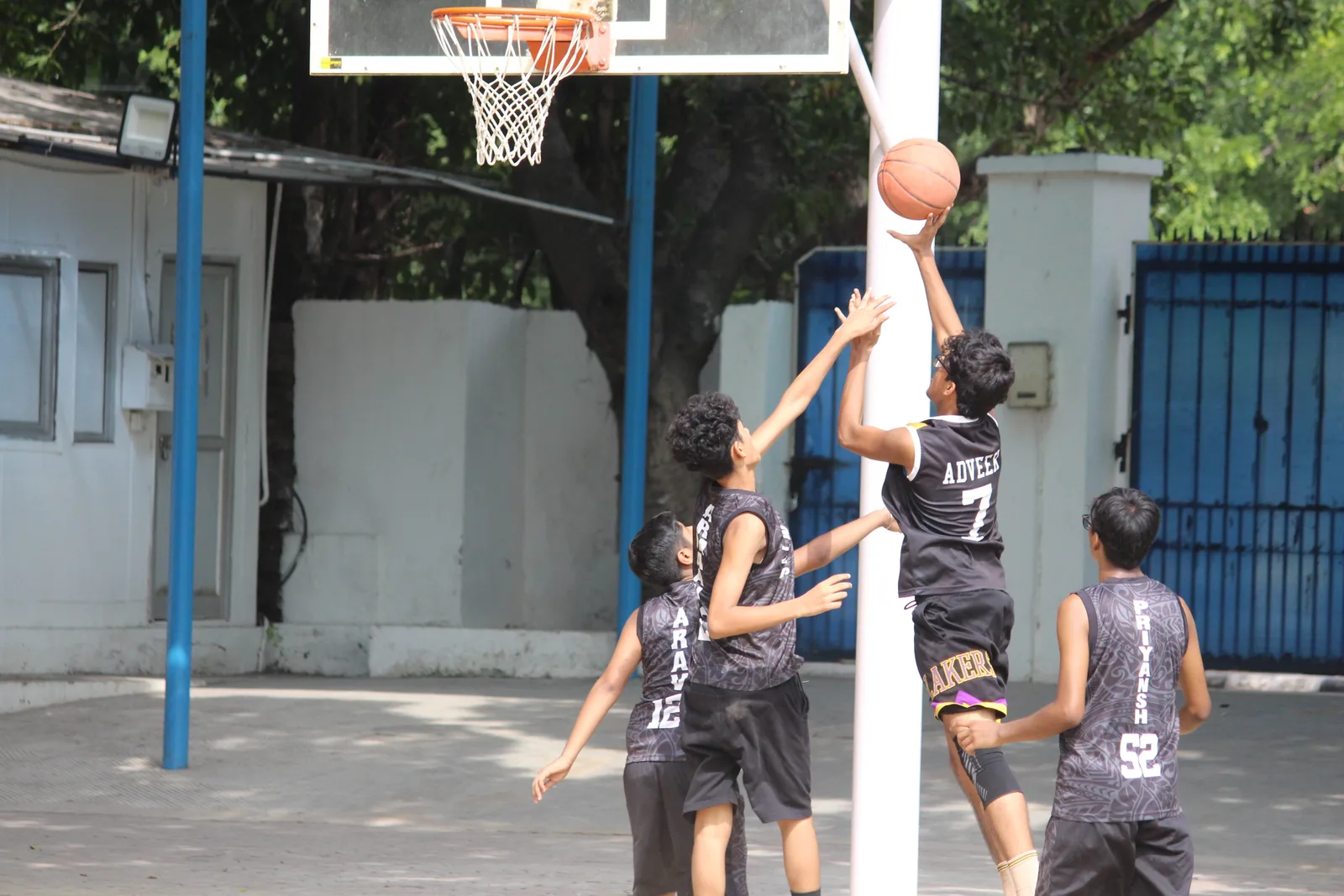 A basketball match in progress on the school court